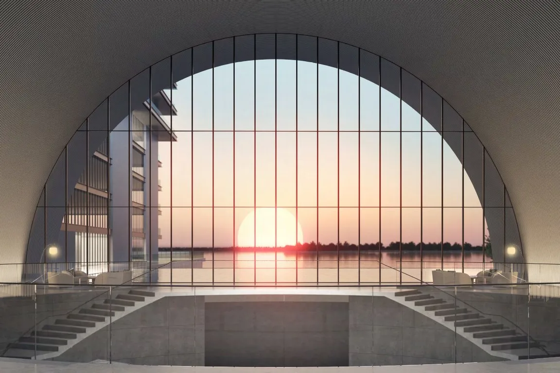 Elevated entrance under a great glazed arch looking out to the sunset